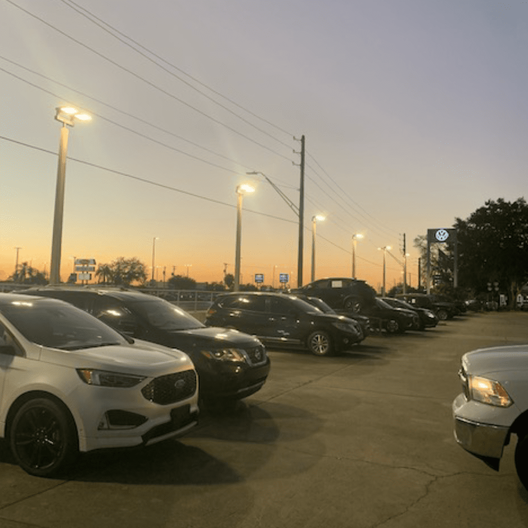 Lightposts in a parking lot during a sunset
